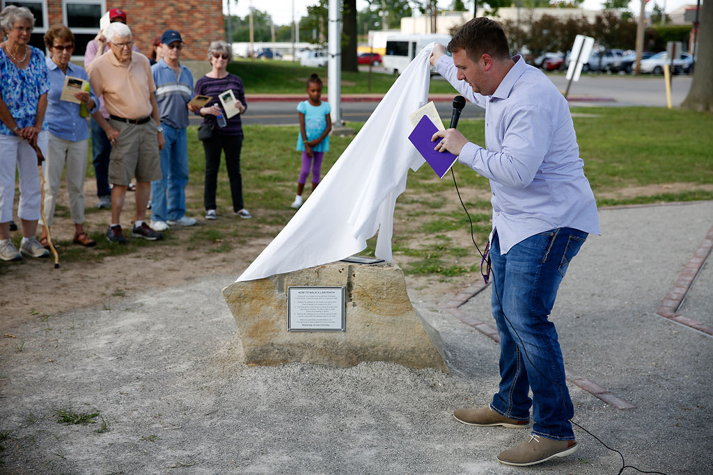 Hickman High School Principal Tony Gragnani unveils a memorial stone resting next to the Janna Fick Labyrinth